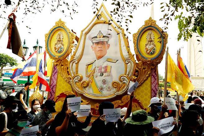 臉書24日才在泰國政府施壓下，封鎖一個有百萬名成員的批判泰國王室的臉書社團，不過該社團創辦人已經另外設立新社團，新社團建立才一天就湧進50萬人加入。圖為示威民眾經過泰王瓦吉拉隆功肖像。（資料照／路透社）