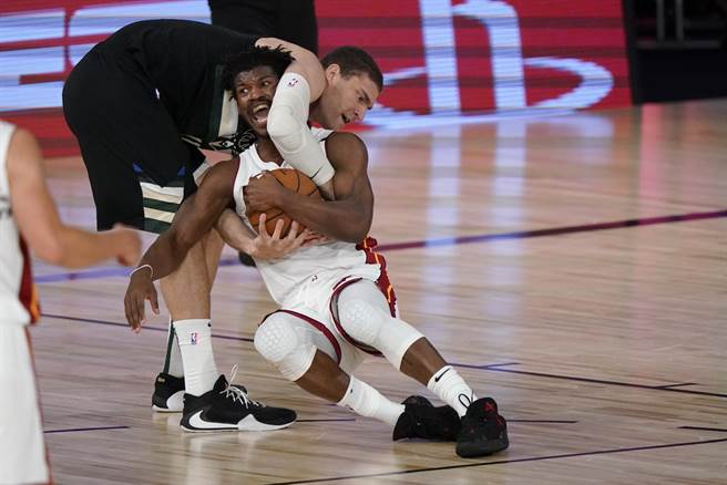 热火前锋吉米巴特勒跟公鹿中锋布鲁克罗培兹争球互不相让。(美联社)