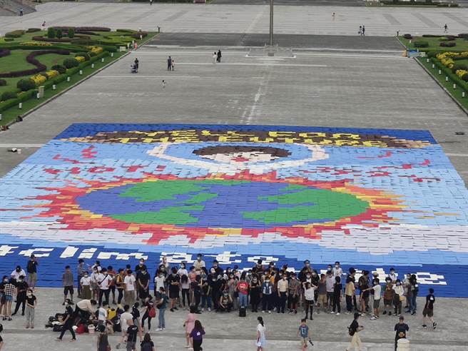 上百位高中、大學青年今天與綠色和平今天排出大型藝術拼圖，希望傳遞年輕世代呼籲各界關注氣候緊急狀態。（林良齊攝）