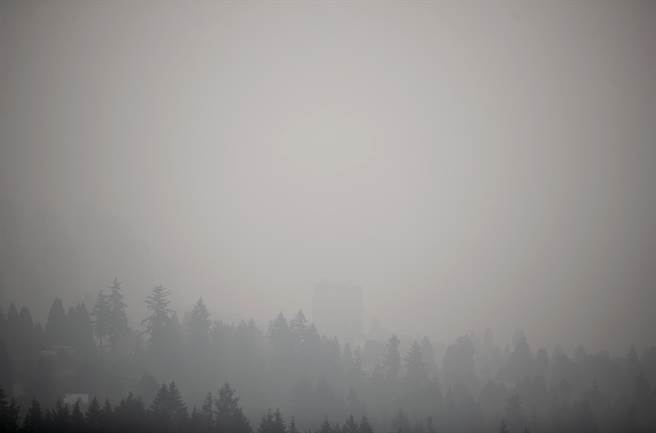 野火持續肆虐美國西岸之際，大片霧霾已經飄向北方，12日加拿大溫哥華淪為全球空汙最嚴重的城市，天空染成灰濛濛一片，市區建築物已看不清。圖為12日溫哥華天空畫面。（圖／TPG、達志影像）