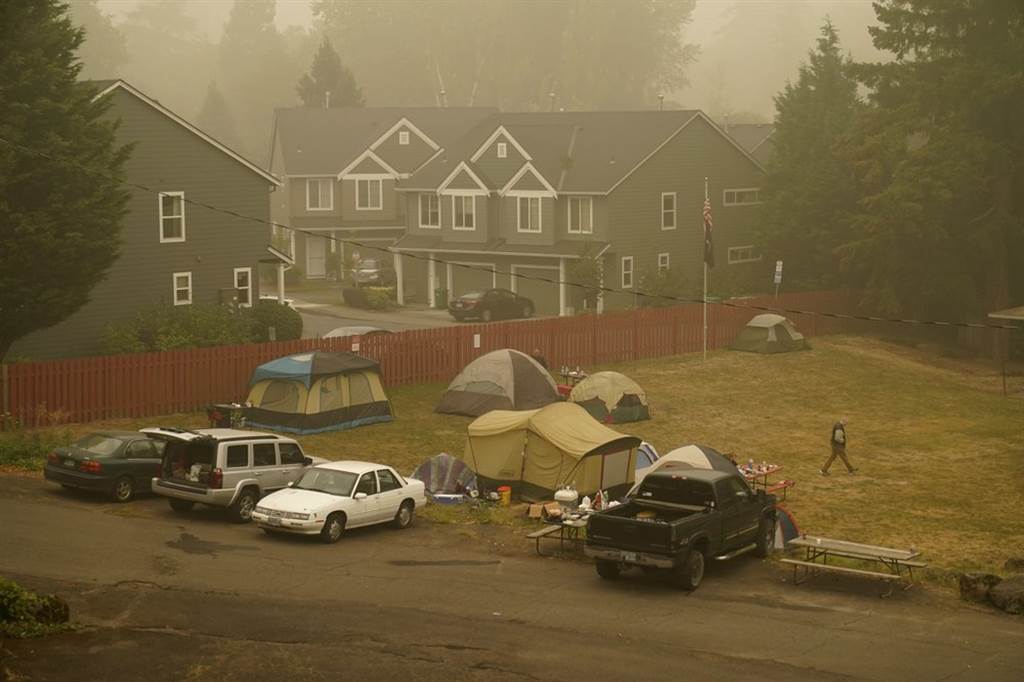 美國西部的嚴重野火，許多居民撤離家園，暫居在帳篷裡。天空呈現汙濁的灰褐色。(圖/美聯社)