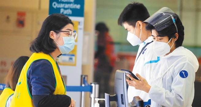 图为桃园机场入境管制区内，2名身穿防护衣、从菲国搭机抵台的旅客，正在查验健康声明书。（资料照片 范扬光摄）