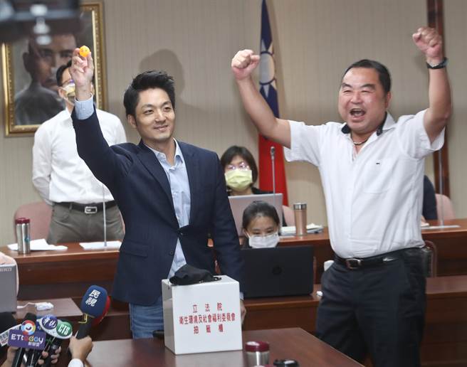 立法院社会福利及卫生环境委员会9月23日举行召委选举，开票过程中，因有一张关键选票盖了两个戳印给洪申翰，引发选票是否有效的争议，经过争论、沟通，最终，会议主席认定该选票为有效票，并由国民党立委蒋万安（左）、民进党立委洪申翰及陈莹三人抽籤争取两席召委；蒋万安率先上场抽籤，顺利抽中召委，蒋与一旁的同党籍立委徐志荣（右）振臂欢呼庆祝，而洪申翰虽抽中，但礼让陈莹，因此，卫环委员会本会期由陈莹及蒋万安担任召委。（图／本报系资料照）