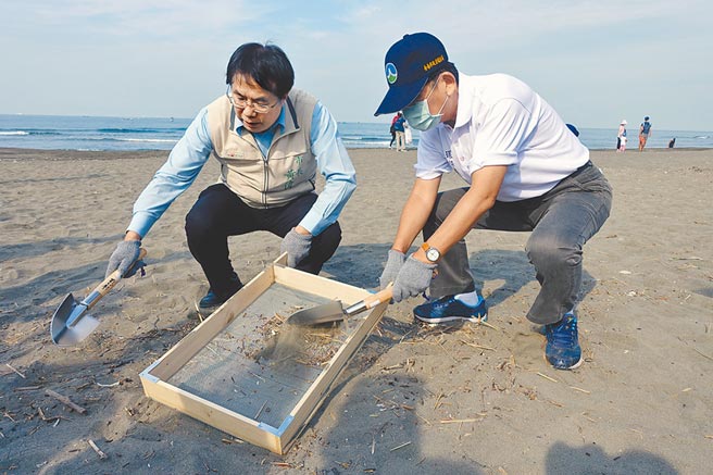 台南市长黄伟哲（左）、市府环保局长谢世杰（右）利用细密筛网清除沙中的废弃物屑。（洪荣志摄）