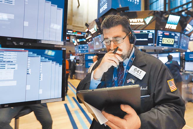 美国纽约证券交易所内，一名交易员正在研究盘势。川普总统新冠肺炎确诊，衝击美国和全球市场。（美联社）