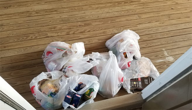 近日一位居住在美国的网友开门看到7大袋装满食物零嘴的陌生包裹，令他满头问号。（摘自PTT）