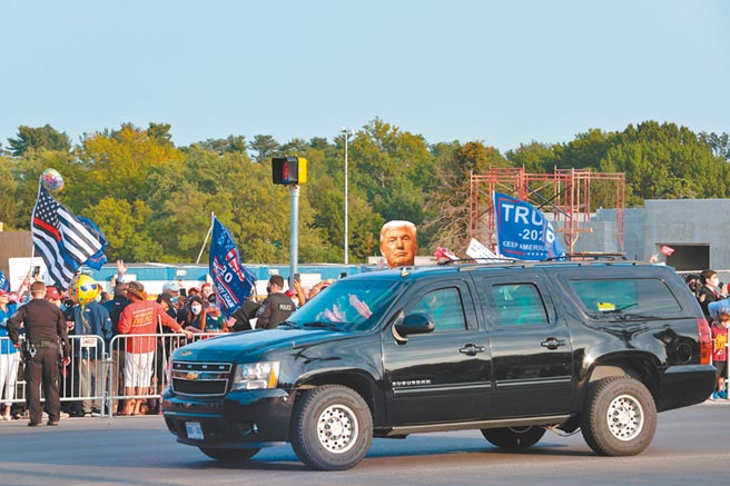 美国总统川普，4日竟然乘坐专车离开医院，在院外短暂绕了一圈。戴着深色布制口罩的川普，向车外为他加油的群眾挥手。前座2位秘勤局人员，均戴着N95口罩。（路透）