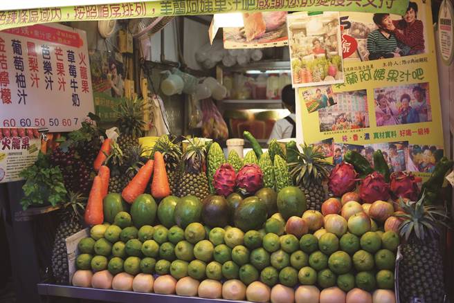 「美蘭阿姨果汁吧」堆滿色彩繽紛的蔬果，小攤上還貼有與名人的合照。(攝影／Karren kao)