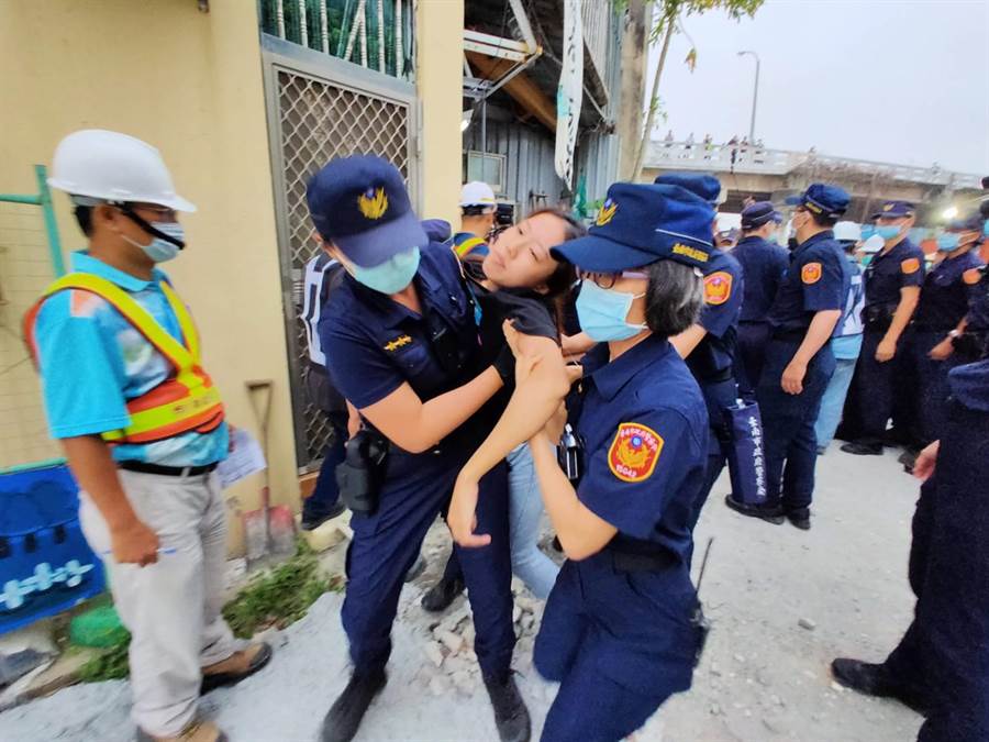 僵持10分鐘後，警方破門而入將人綠續駕出。（洪榮志攝）