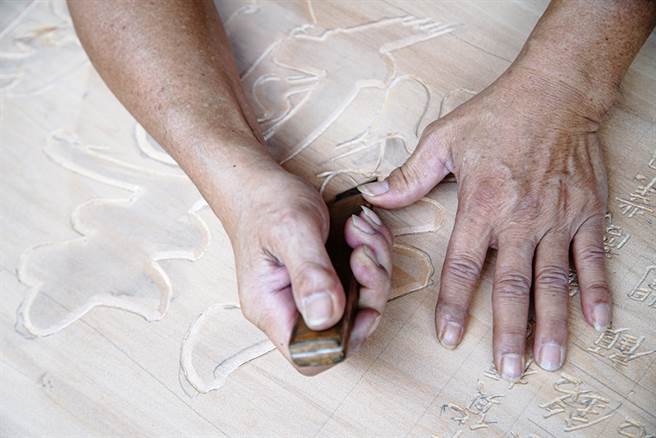 吳崑章擁有30多年手藝，將屬於國寶級的手寫藝術躍然於匾額上。（圖/曾信耀攝）