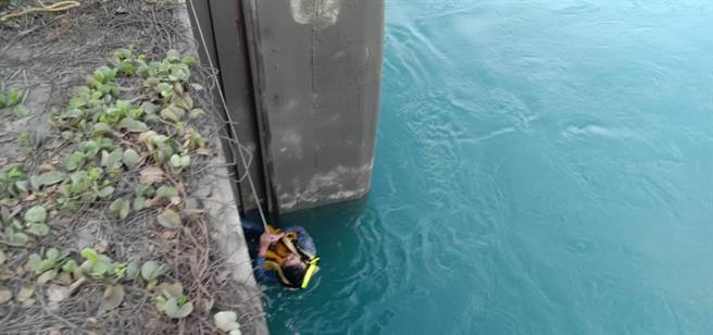 男子落水後雙手攀住水門，幸遭消防人員救起。（民眾提供／陳淑娥台中傳真）