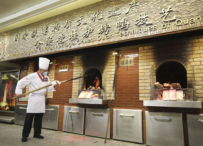 北京全聚德举办挂炉烤鸭技艺比赛，厨师正在展示烤鸭制作技艺。（图／中新社）
