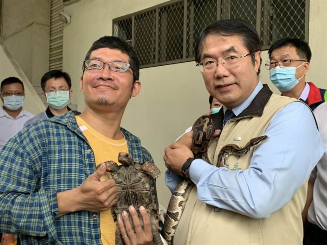 台南市长黄伟哲（右）7日出席动保宣传活动，巧遇民眾带着陆龟、球蟒参加，并邀请黄伟哲与宠物合影。（李宜杰摄）