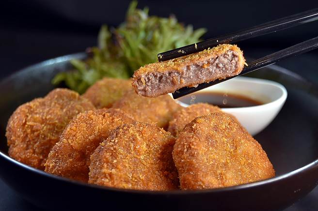 「炸和牛肉饼」是用和牛绞肉混入洋葱、鸡蛋和香料拌匀，塑成饼状沾麵衣油炸到金黄，为游东京必尝美味，如今台北喜来登「十二厨」让客人吃到饱。（图／姚舜）