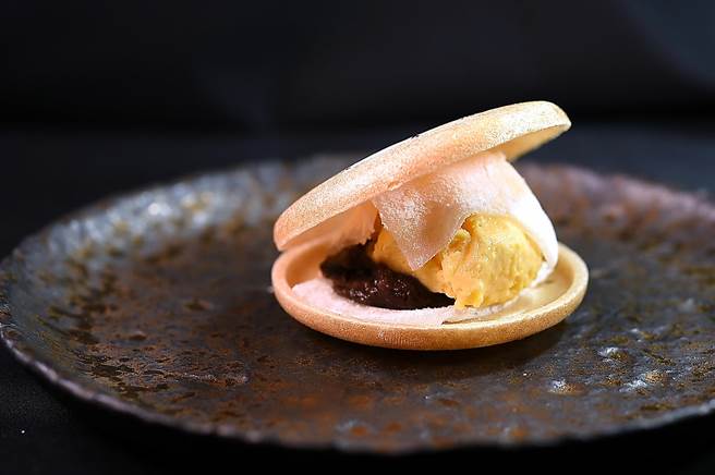 〈寿司芳〉季节限定「大闸蟹宴」的甜点，最中饼内夹着红豆泥、薄片麻糬，以及咸蛋黄作的冰淇淋，甜咸交织、软脆 共陈、好吃极了。（图／姚舜）