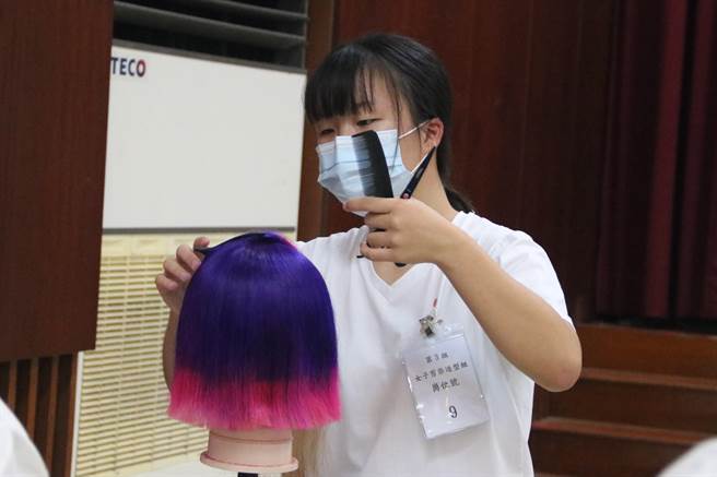 弘光美髮系学生江宜儒领取助学金专心比赛。（陈淑娥摄）