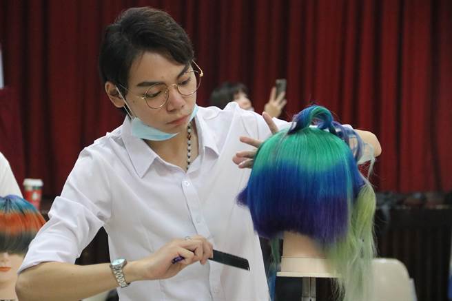 弘光美髮系学生苏冠霖领取助学金专心比赛。（陈淑娥摄）