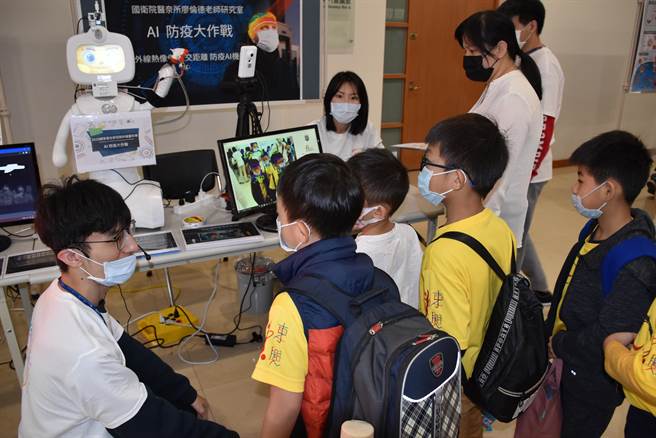 国卫院科普日展出AI智慧防疫机器人，吸引小朋友好奇观看。（谢明俊摄）