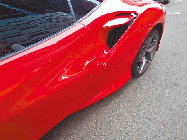 台中市西屯区10日下午，发生女机车骑士因外套卷入机车底的散热风扇，造成机车滑倒，不偏不倚擦撞上停等红灯、市价约1485万的红色法拉利F8 Tribut跑车，女骑士手脚擦挫伤，但擦撞法拉利「赔大了」，原厂估算修车费约120万。惊方初判责任在女骑士，肇事原因还要进一步调查厘清。（图：民眾提供 文：卢金足）