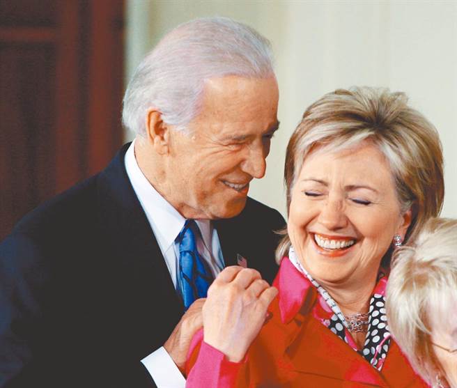 2009年1月29日，时任美国副总统的拜登（左）与国务卿的希拉蕊在白宫东厢参加一场反性别歧视法案签字仪式时，亲切互动。（路透）