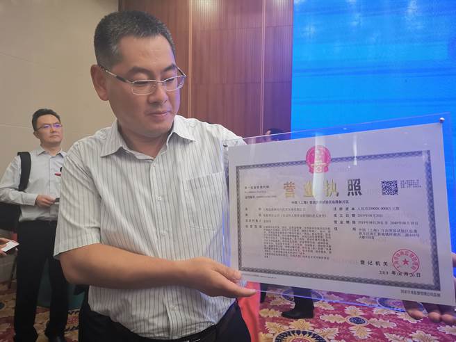 大陆近期兴起企业取怪名热潮。图为去年上海自由贸易试验区临港新片区揭牌典礼上，入驻企业展示注册通过后所获营业执照。(中新社资料照片)