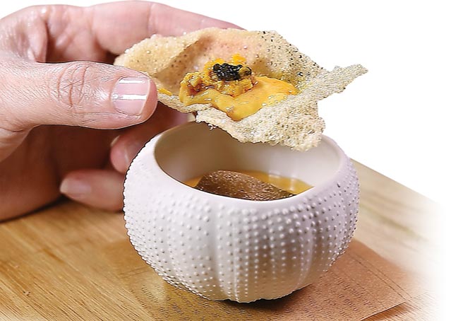 〈海胆松露炒蛋佐大闸蟹膏〉可用汤匙舀着入口吃，也可以搭配用寿司米饭作的米饼享用。图／姚舜