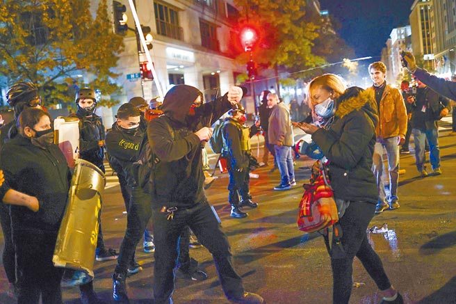 支持川普的極右派反移民團體「驕傲男孩」成員，14日晚間在華府街頭，與反川普示威人士爆發肢體衝突。（路透）