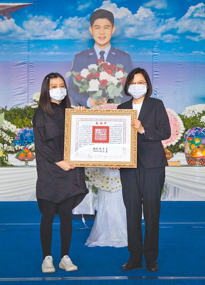 空军司令部于17日上午为殉职飞官朱冠甍举行烈士公祭典礼，蔡英文总统（右）颁发褒扬令，由朱妻（左）代表受赠。（蔡旻妤摄）