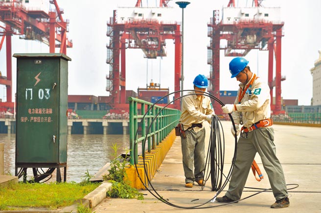 江蘇江陰蘇南國際碼頭，技術人員為靠港的船舶接入變頻電源裝置。（新華社資料照片）