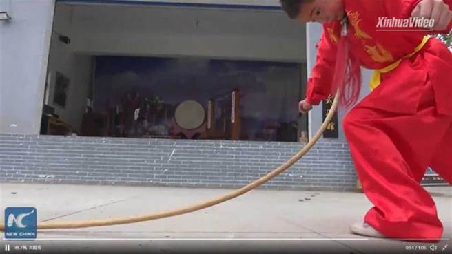 小朋友將中式長槍的尖銳槍頭抵在喉嚨處，用全身力量將槍桿折彎。（圖／新華社推特）