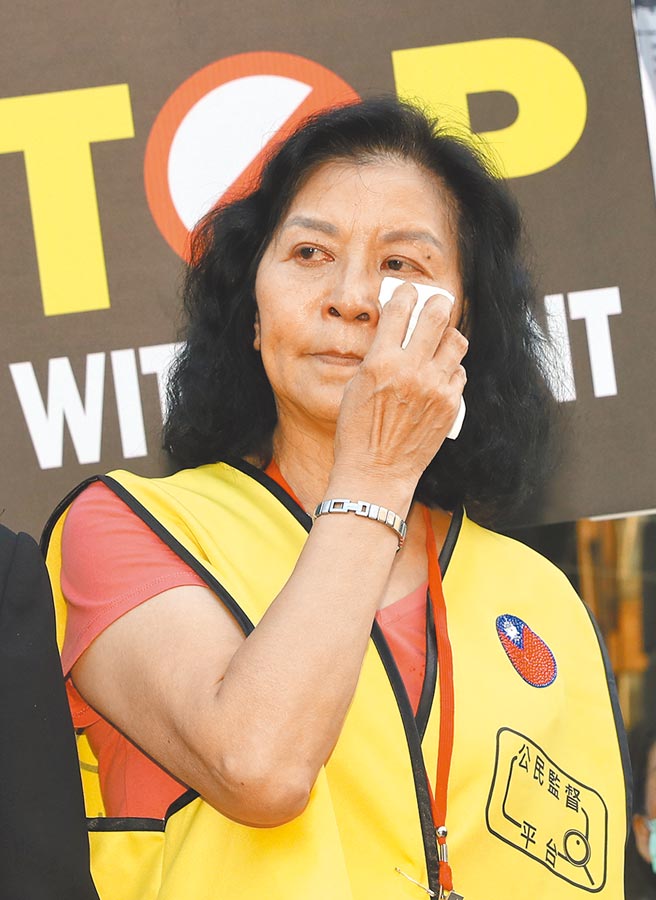 NCC拒让中天新闻台换照，引发外界质疑打压新闻自由。公民监督平台等团体昨前往NCC抗议，前新闻局长锺琴在民进党旗上喷漆，并把党旗撕毁，表达不满。她泪诉18日是中华民国新闻史最黑暗的一天。（刘宗龙摄）