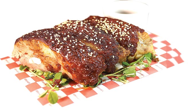 〈窯烤豬肋排〉，是用優質豬的腩排製作，鮮嫩有彈性還能吃到骨汁的甘味，較傳統美式餐廳的好吃。圖／姚舜