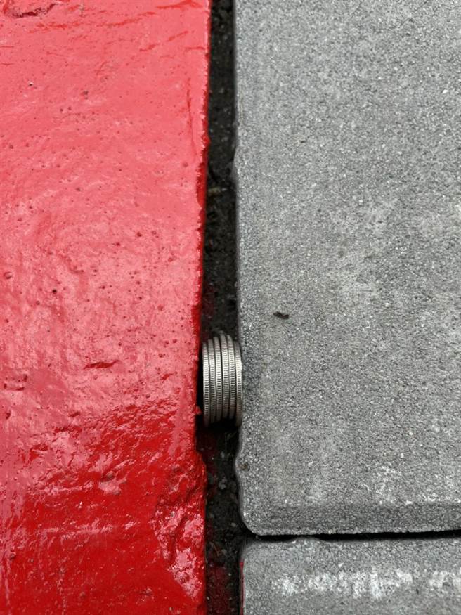 北市内湖大湖社区入口人行道日前才更新完成，但议员李明贤却发现，地板的裂缝居然可放入6个铜板。（李明贤提供／张颖齐台北传真）