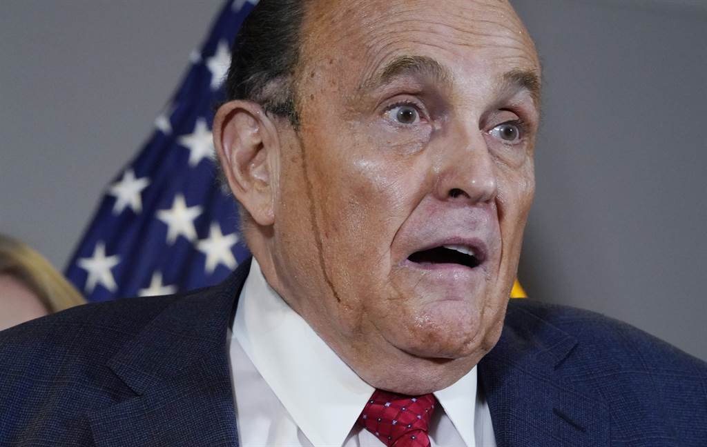 身為美國總統川普法律團隊主將的紐約前市長朱利安尼（Rudy Giuliani）19日在華府舉行記者會時滿頭大汗。（美聯社）