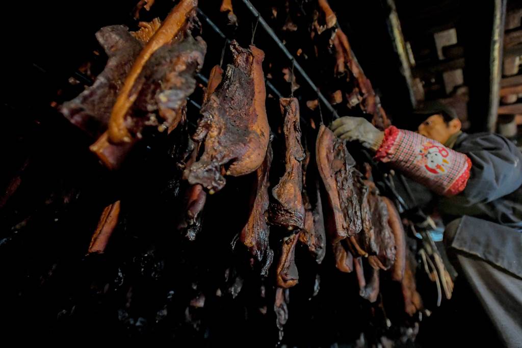 燻烤中的臘肉。（新華社資料）