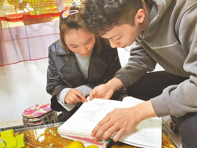 作者（右）鼓励脱贫户家庭读中学的小女孩。（作者提供）