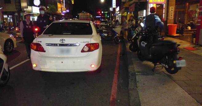 许姓男子开着白色轿车违停在红线区，跨越马路到对面买消夜被机车撞，全身是伤还要吞罚单，得不偿失。（图／翻摄画面）