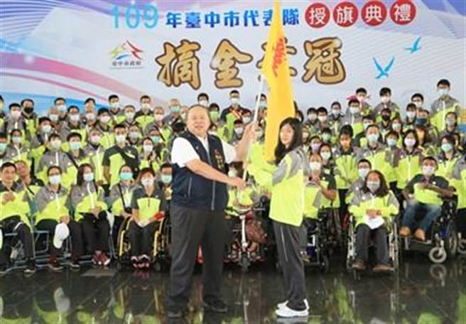 台中市副市长陈子敬颁授市旗给参加全国身心障碍国民运动会选手代表许乐。（卢金足摄）