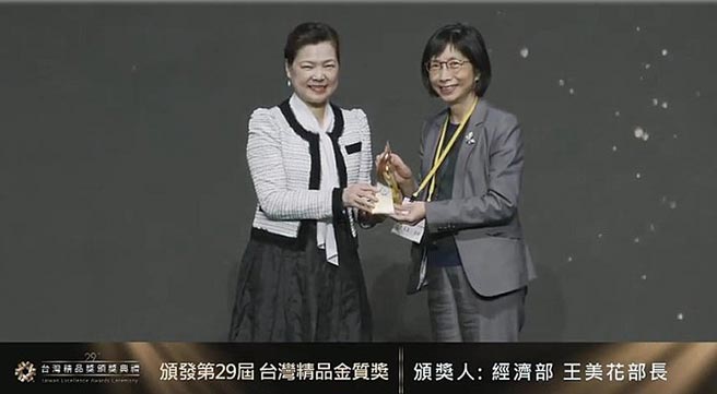 东元董事长邱纯枝25日从经济部长王美花手中接下今年台湾精品奖金质奖。图／东元提供