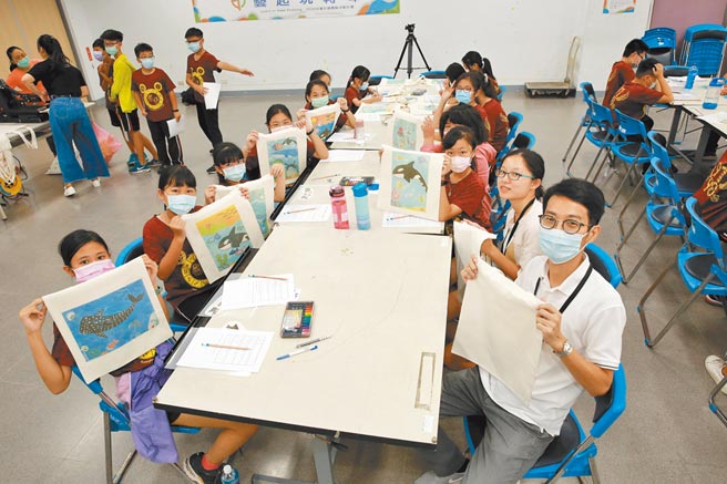 透过热转印技术，援中国小学童将海洋世界作品转印到帆布袋上，开心展示作品。（林瑞益摄）