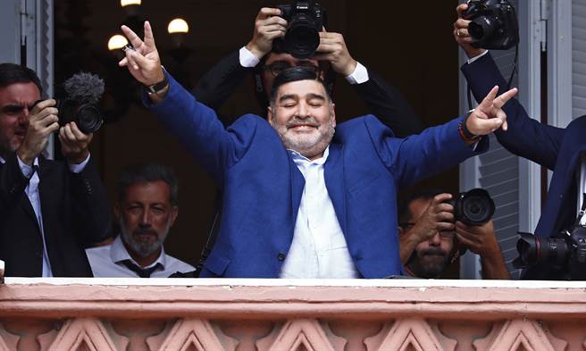 阿根廷足坛传奇球星马拉度纳2019年12月在总统府与最高行政中心「玫瑰宫」（Casa Rosada）向球迷致意的神情。（美联社）