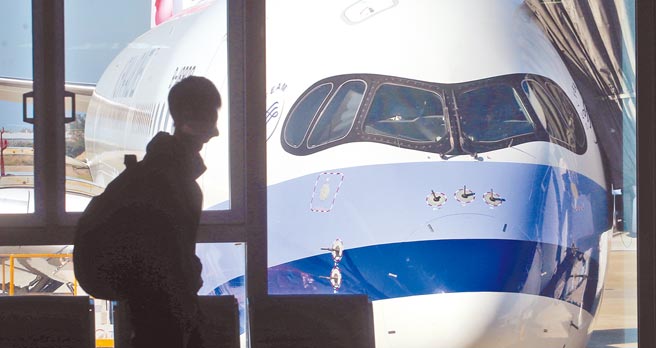 受新冠肺炎疫情影响，许多在国外就学的台湾籍学生纷纷返台就学，其中不乏名校学生。在桃园机场入境管制区内，1名旅客走过候机室的落地窗前。（范扬光摄）