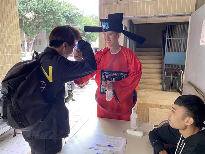 台银菜鸟周暐宸不仅穿上财神装，更负责在门口测量体温。(黄及人摄)