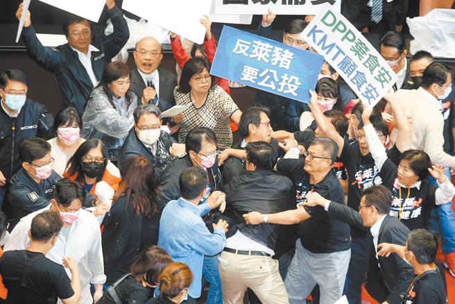 行政院無視民意反彈決進口萊豬，國民黨昨強力杯葛施政報告，高喊「蘇貞昌下台」，蘇揆由綠委層層護航上台，藍委見狀，豬心、豬腸、豬油齊飛拋向主席台，沾得綠「一身腥」。（杜宜諳、姚志平攝）