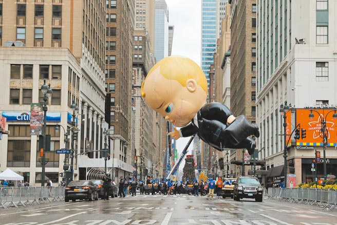 美國紐約市曼哈頓區一年一度梅西百貨感恩節大遊行活動26日登場，受到新冠疫情影響，今年活動不對民眾開放，改採電視轉播。圖為卡通人物「寶貝老闆」氣球飄過沒有人群聚集的街道。（路透）