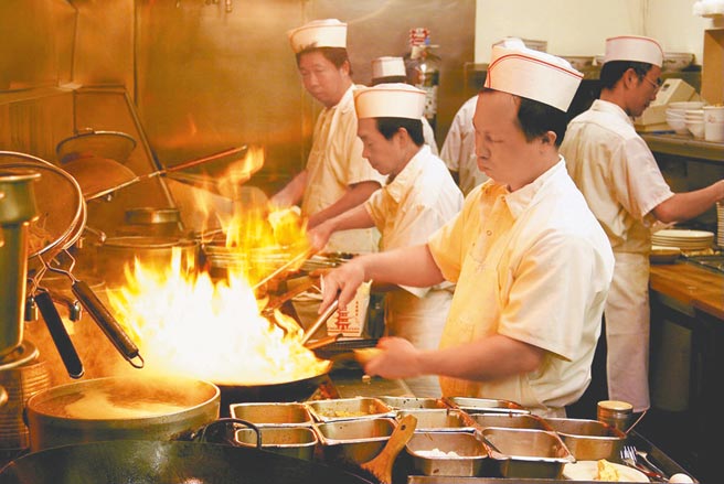 快炒店师傅左手掌锅，右手掌勺，火焰喷张之刻，一碟碟的美味秒杀出餐。（梁幼祥提供）