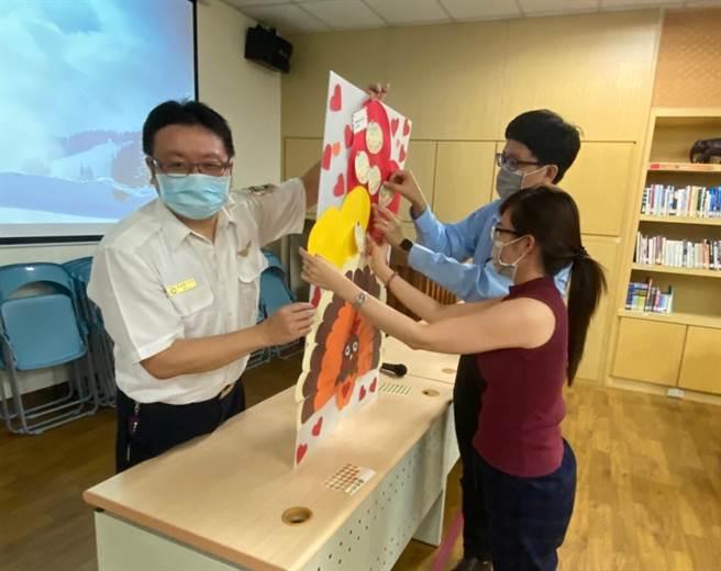 移民署南区事务大队高雄市第二服务站日前举办活动，夫妻共同贴上心愿小纸卡至心愿板上。（移民署提供／林瑞益高雄传真）