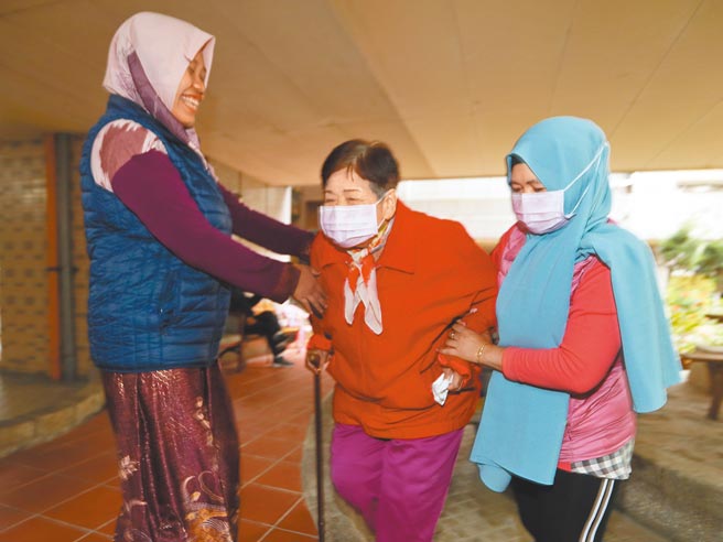 因应印尼移工武汉肺炎境外移入个案暴增，且移工管理状况不佳，中央流行疫情指挥中心30日宣布12月4日起暂时禁止印尼移工入境2周，恐衝击不少家庭和照护机构。图为印尼看护工扶着雇主散步。（陈怡诚摄）