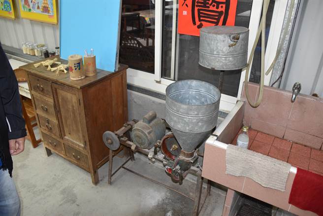 刘明芳用数10年歷史的老石磨来磨制米浆。（谢明俊摄）