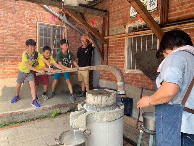 文化协会安排用老石磨来磨制米浆做成红龟粿。（传统聚落文化协会提供／谢明俊苗栗传真））